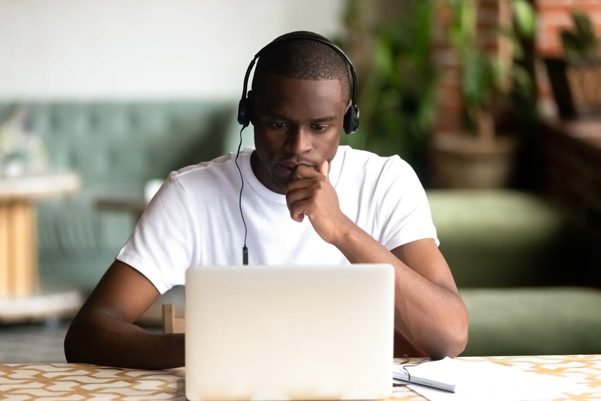 young Black man working seriously at a laptop